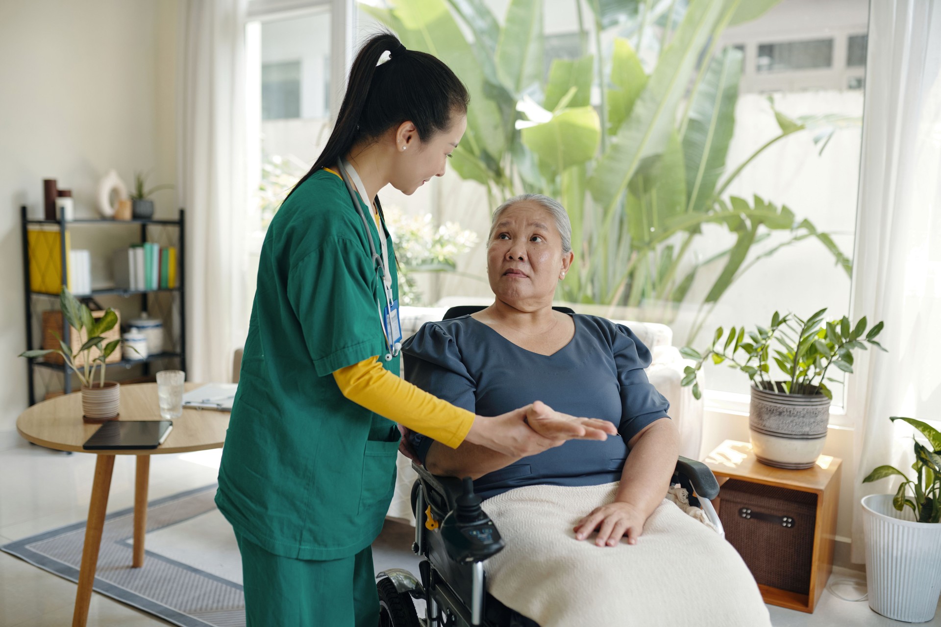 Nurse Examining Pulse Of Senior Patient